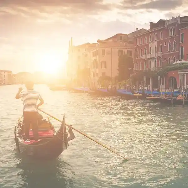 Landschaftsbild Italien vom Fluss von Venedig, einer Häuserreihe rechts und einem Schifffahrer links.